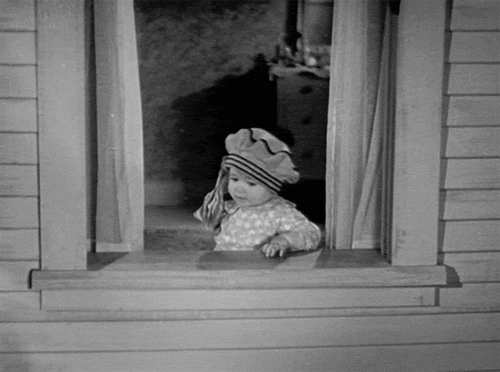 Movie gif. In black and white, a toddler from The Little Rascals leans on a window sill and throws a handful of dollar bills out the window, watching them fall.