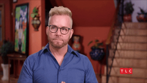 Reality TV gif. Kenny from 90 Day Fiance brings his hands to his lips in a gesture of hopefulness.