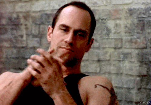 TV gif. Christopher Meloni as Chris in OZ leans back as he claps his hands with force. 