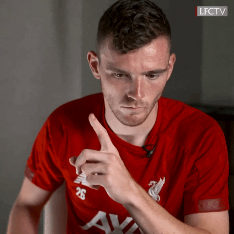 Sports gif. Andy Robertson wears a Liverpool Premier league jersey as he leans forward in his seat. He looks down, concentrates on thinking, and wags his finger. He then says, “True.”