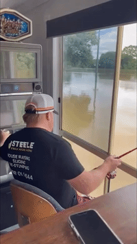 Queensland Man Enjoys Beer While Fishing in Floodwaters