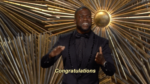 Celebrity gif. Kevin Hart on the Academy Awards stands on stage looking out at the crowd. He nods his head, giving a big slow clap as he says, “Congratulations.”