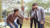Reality TV gif. Four members on Down to the Studs raise their hands excitedly from a team huddle. 