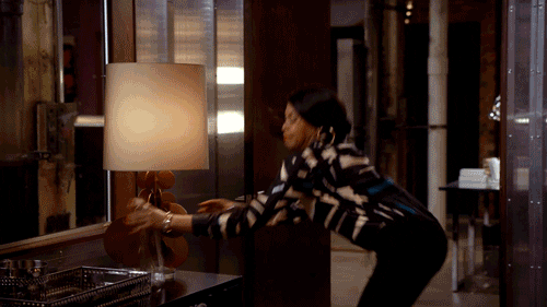 TV gif. Taraji P. Henson as Cookie in Empire snatches a glass vase from the table and chucks it at the window, watching it shatter against the glass.