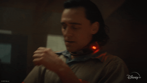 TV gif. Tom Hiddleston as Loki in Loki. He's in jail and has a collar around his neck to prevent him from using his powers. He's sitting in a chair and frustratedly drops his head into his hands.