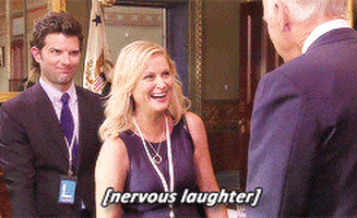 Parks and Recreation gif. Amy Poehler as Leslie and Adam Scott as Ben are talking to someone and looking very uncomfortable and awkward. Leslie laughs stiffly and shakes their hand and the text reads, "nervous laughter."