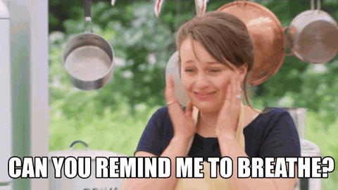 Reality TV gif. A contestant on the Great British Bake Off looks incredibly nervous as she holds her face in her palms and shakes her hands out. She looks at the hosts half-joking and asks them, "Can you remind me to breathe!?"