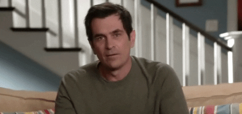 TV gif. Ty Burrell as Phil on Modern Family sits on a couch in the living room as he points at us beginning to form the F sound on his lips. He stops himself and gives us a thumbs up before pointing again and saying, "Yeah."