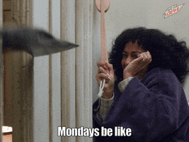 Ad gif. A woman in a Mountain Dew ad is backed up in a corner as she screams and slides down the wall. She uses a wooden ladle to attempt to bat an axe away. Text, "Mondays be like."