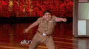 Video gif. Young boy on the Ellen Show dances in a circle, shaking his hips and throwing his arm in the air.