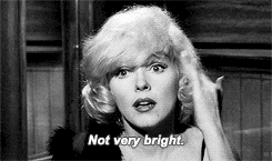 Movie gif. Marilyn Monroe as Sugar in Some Like It Hot taps the side of her head with wide eyes. She shakes her head and says, “Not very bright.”