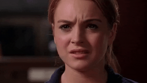 Movie gif. Lindsay Lohan as Cady Heron in Mean Girls grimaces with restrained chagrin.
