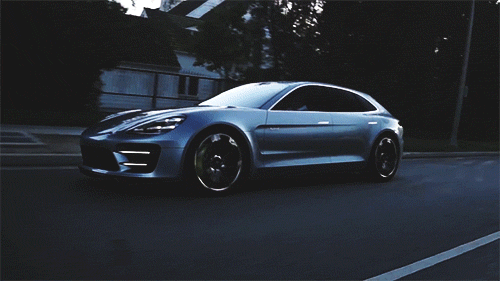 Video gif. A brand new silver Porsche Panamera Sport Turismo drives smoothly down the road.