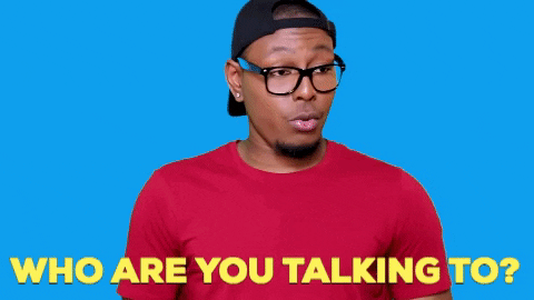 Video gif. Terrell Grice has glasses and a backwards cap on and he stares at us challengingly, asking, "Who are you talking to?"