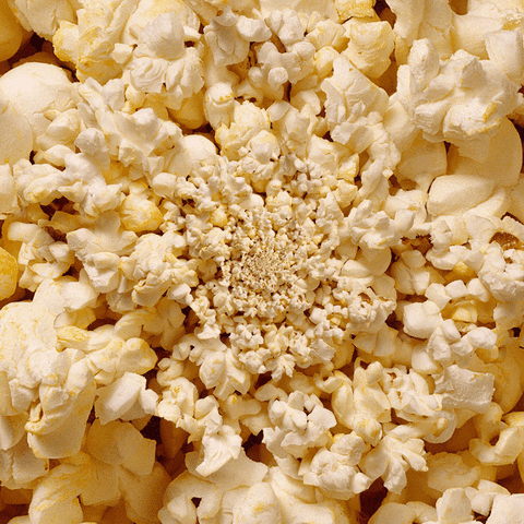 Video gif. We zoom in on a mound of popcorn as the camera turns in circles.