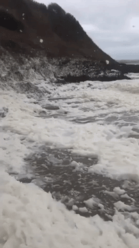 Sea Foam Covers Beach in Aberdaron, Wales, After Storm Barra Hits the Region