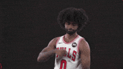 Sports gif. Coby White of the Chicago Bulls wears his jersey as he dances in celebration, rolling his hands and doing the nay nay.