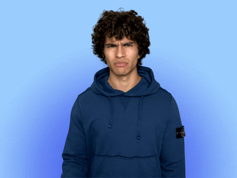 Video gif. A man stares at us with a super confused expression on his face. He rubs the back of his head as question marks pop up around him. 