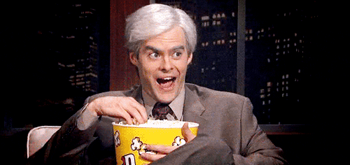 Celebrity gif. A captivated Bill Hader nods and smiles as he eats popcorn.