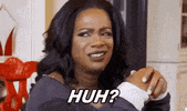 Video gif. A woman glances to the side with a raised eyebrow. Text, "Huh?"