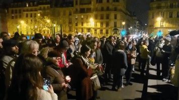 Parisians Gather to Sing Hymns at Notre Dame Cathedral After Fire