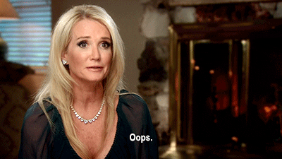 Reality TV gif. Kim Richards from Real Housewives of Beverly Hills shrugs and laughs, saying, "Oops," nonchalantly.