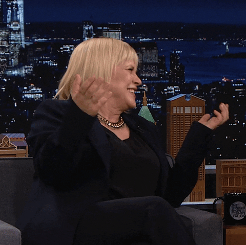 Tonight Show gif. Patricia Arquette raises a fist in the air and does a small fist pump while laughing and saying, "Boom!"