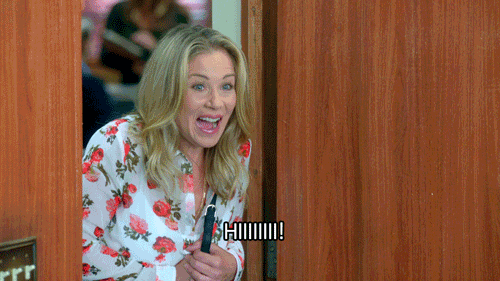 TV gif. Christina Applegate as Gail Budnick on The Grinder steps into a room as she nervously says, “Hiiiiii!”
