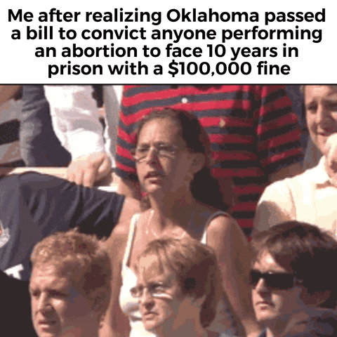 Meme gif. Woman in an outdoor crowd, wearing a white tank top and visibly sweating, curls her fingers into her hands and flails her arms around angrily, straining as she screams and shouts. Text, "Me after realizing Oklahoma passed a bill to convict anyone performing an abortion to face ten years in prison with a one-hundred-thousand-dollar fine."