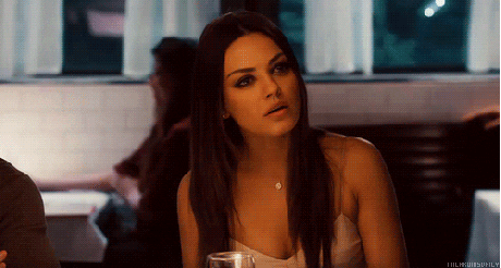 Celebrity gif. Sitting in a restaurant, Mila Kunis nods her head and frowns in agreement.