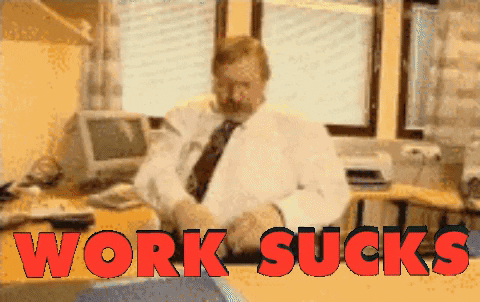 Video gif. Man sitting behind an office desk flipping papers and folders up in frustration. Text, "work sucks."