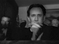 Celebrity gif. Nicolas Cage's face is superimposed over Orson Welles as Charles Foster Kane in Citizen Kane, clapping his hands slowly in a theater.
