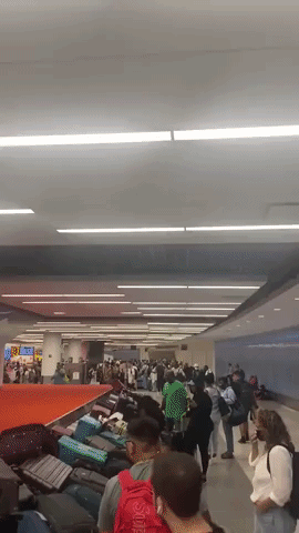 Luggage Piles Up at JFK Baggage Claim Amid Large Crowds
