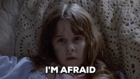 Movie gif. Regan MacNeil as Linda Blair in The Exorcist lays in bed, looking pale white like a corpse. She looks out into space and weakly says, “I’m afraid.”