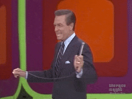 TV gif. A young Bob Barker on "The Price is Right" smiles genuinely and turns towards us, holding the wire of his skinny microphone on set. Text, "Thank you."