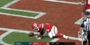 Sports gif. Kareem Hunt wears his helmet and uniform as he uses a football for a pillow and lies down with it in the middle of the field.