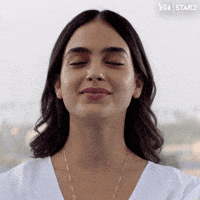 TV gif. Dressed in white, Melissa Barrera as Lyn from Vida smiles slightly and gulps, eyes closed.