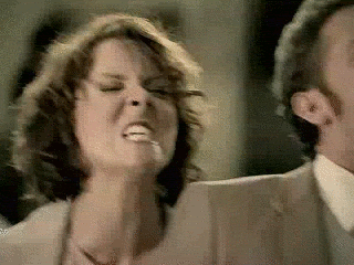 Video gif. Furiously angry woman with bulging eyes and a monstrous face.
