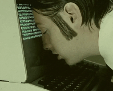 Music video gif. A man in the music video for "The Golden Path" by The Chemical Brothers has his head leaning on a computer and he looks totally destroyed and tired. 
