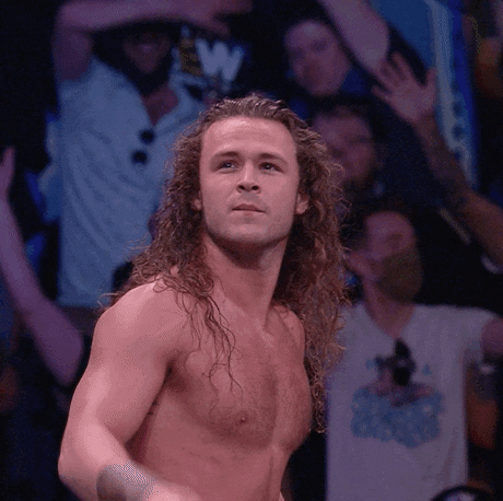 Celebrity gif. Wrestler Jack Perry, "Jungle Boy" stands shirtless in front of an audience. He raises a pointed finger and looks with eager eyes into the distance.