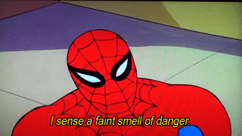 Cartoon gif. Spider-Man squints his eyes behind his mask and says, “I sense a faint smell of danger.” He then turns his head and a gun is pointed right at him.