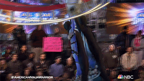 TV gif. In a scene from American Ninja Warrior, two contestants slide off of a set of high rails, flip in midair, and fall into a pool.