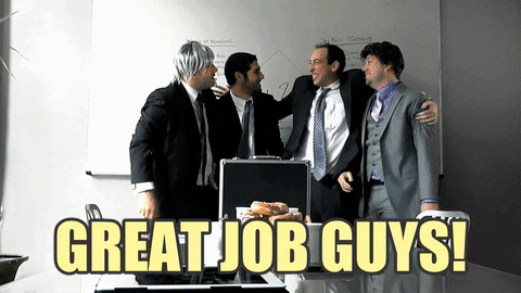 TV gif. Four men in business attire join hands and then leap into the air at the same time, where the picture freezes. Text, "Great job guys!"