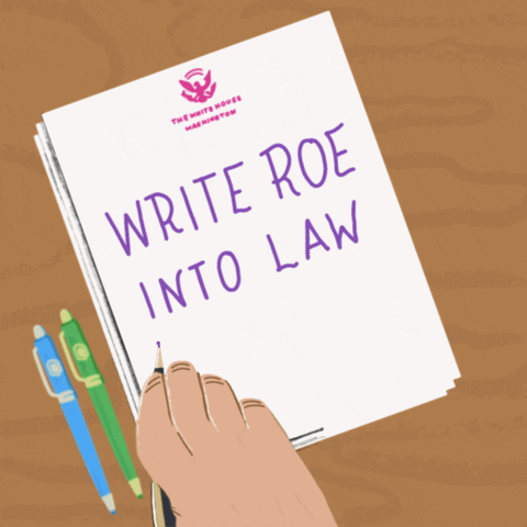 Digital art gif. Illustration of a hand writing on a piece of paper with the White House seal on it. The hand writes the text, "Write Roe into law," in all-caps, purple letters, and underlines it.