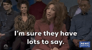 Video gif. Saturday Night Live castmember Mikey Day and guest host Ryan Gosling are dressed as Beavis and Butt-head for a sketch. Day and Gosling are sitting in the front row of a talk show audience. The two of them are staring straight ahead with goofy smiles on their faces. 