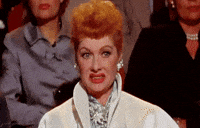 TV gif. Lucille Ball sits in a crowd of people. She pulls her lips back and grimaces in disgust like she wants to look away, but can't. 