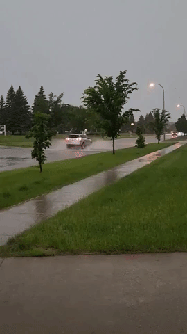 Cars Navigate Flooded Streets as Storm Hits Grand Forks, North Dakota