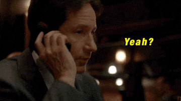TV gif. David Duchovny as Fox in The X-Files. He's on the phone and he looks expectant as he answers with, "Yeah?"