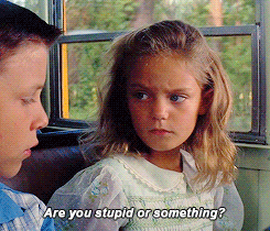 Movie gif. In a scene from Forrest Gump, Jennie as a little girl sits next to Forest on a school bus looking genuinely confused and concerned, saying "Are you stupid or something?'