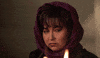 TV gif. Roseanne Barr as Rosanne stares offscreen as fire crackles in front of her.